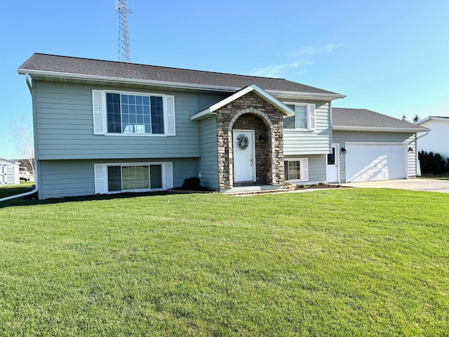bi-level home featuring an attached garage, driveway, and a front yard