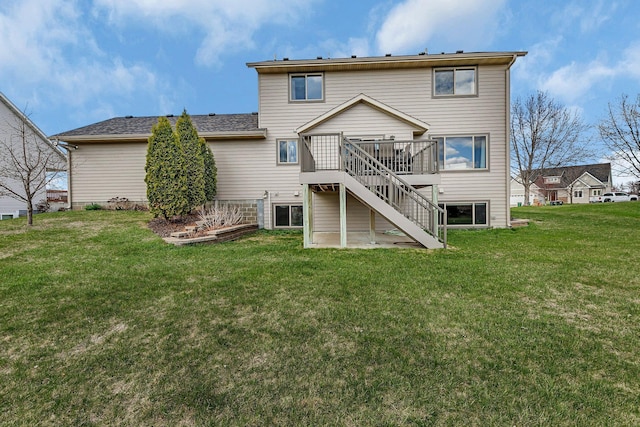 back of house featuring a lawn, a wooden deck, and stairs