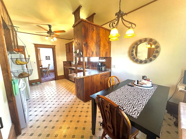 kitchen with ceiling fan, baseboards, brown cabinets, hanging light fixtures, and a sink