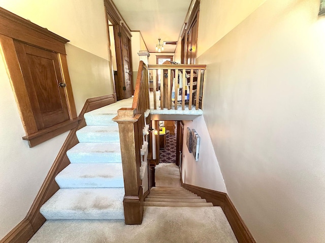 stairs featuring carpet floors and baseboards