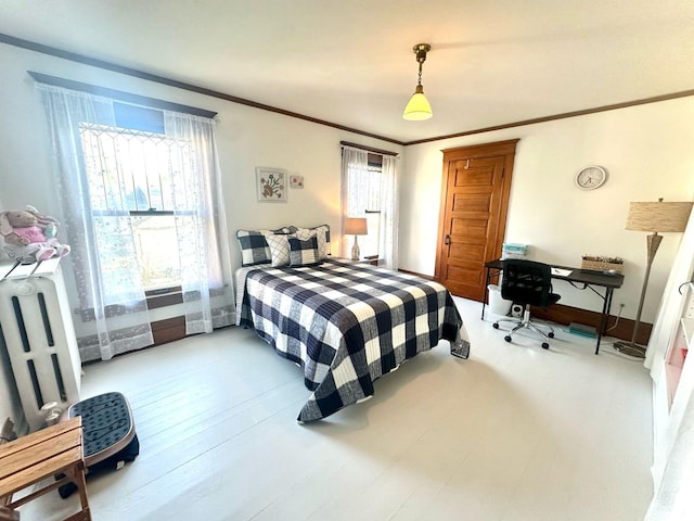 bedroom with ornamental molding, baseboards, and radiator