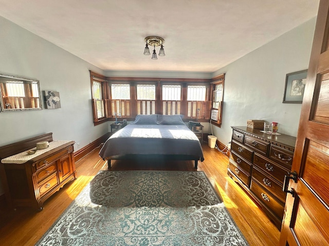 bedroom with light wood finished floors and baseboards