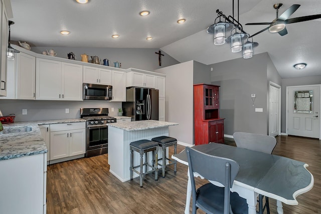 kitchen featuring white cabinets, a kitchen island, vaulted ceiling, and stainless steel appliances