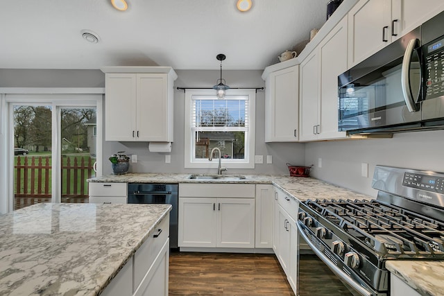 kitchen with white cabinetry, dark wood-style floors, a sink, and stainless steel gas stove