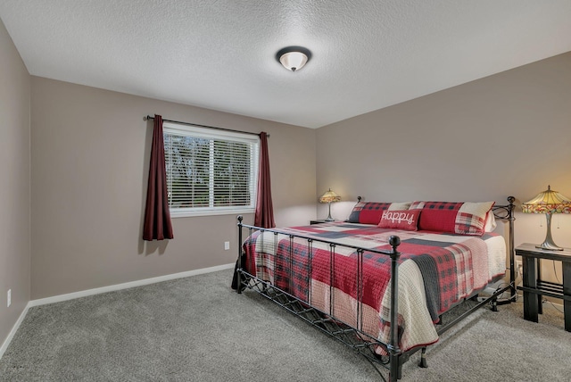 carpeted bedroom with a textured ceiling and baseboards