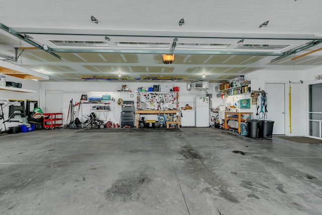 garage with freestanding refrigerator, a workshop area, and a garage door opener