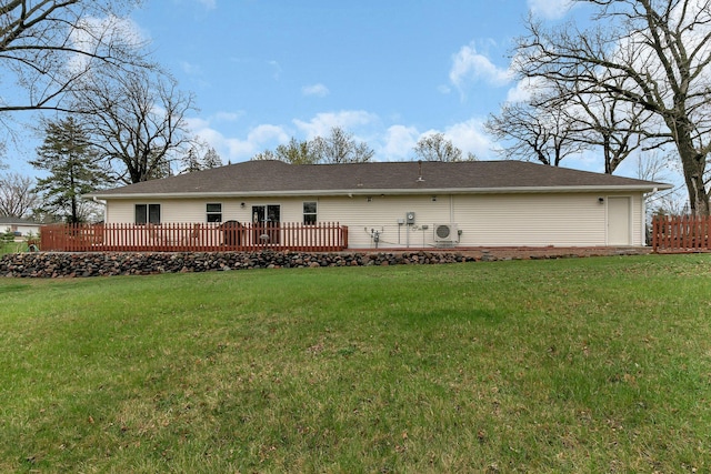 rear view of house with a lawn and roof with shingles
