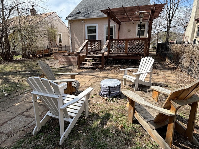 view of patio with a fenced backyard, a wooden deck, a fire pit, and a pergola