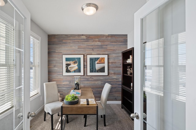office with wooden walls, french doors, an accent wall, carpet, and baseboards