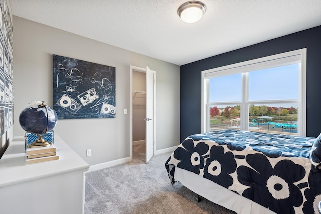 carpeted bedroom with baseboards and a textured ceiling