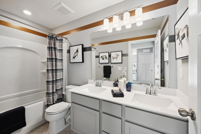 bathroom featuring double vanity, a sink, shower / tub combo, and toilet