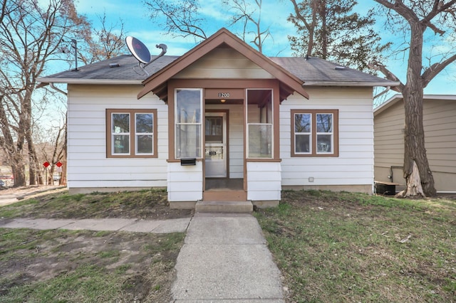 view of front of home featuring a shingled roof and a front yard