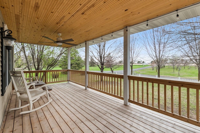 deck with a lawn and ceiling fan