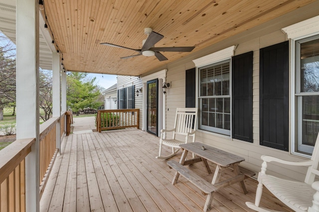 wooden deck featuring covered porch and ceiling fan