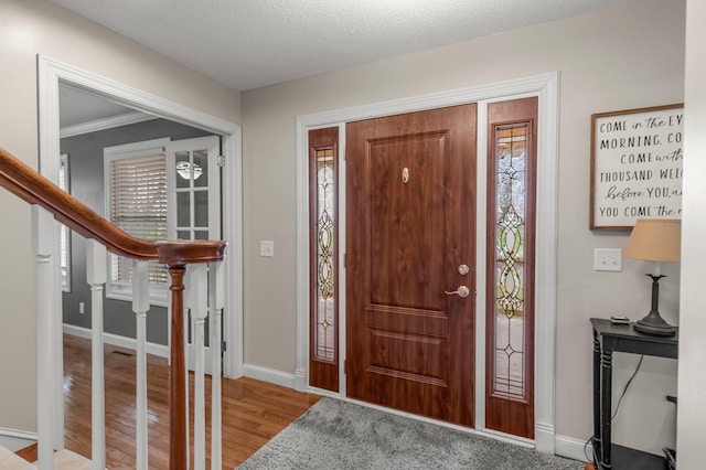 foyer entrance with light wood-type flooring, baseboards, a healthy amount of sunlight, and stairway