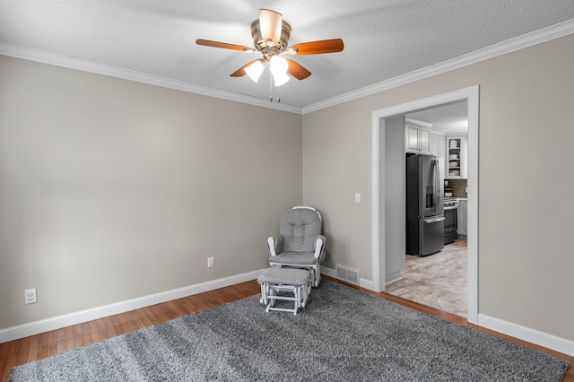 unfurnished room with visible vents, ornamental molding, baseboards, ceiling fan, and light wood-style flooring