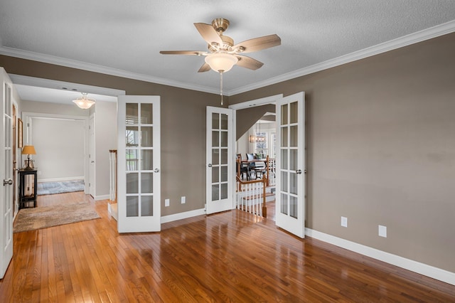 unfurnished room featuring french doors, wood-type flooring, ceiling fan, and baseboards