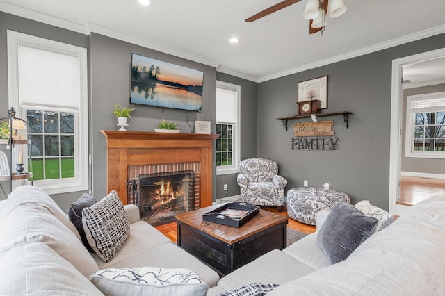 living area with crown molding, recessed lighting, ceiling fan, and a fireplace
