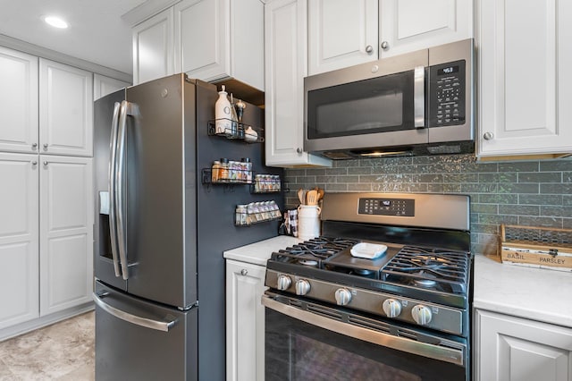 kitchen featuring decorative backsplash, white cabinets, and stainless steel appliances
