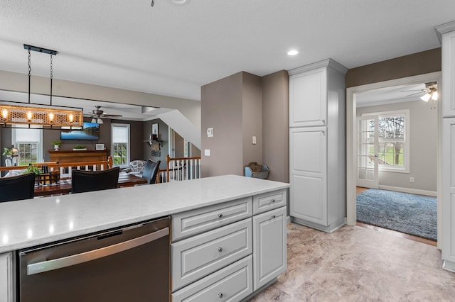 kitchen with stainless steel dishwasher, recessed lighting, ceiling fan, and light stone counters