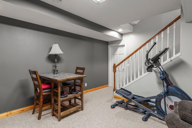exercise room featuring baseboards and carpet