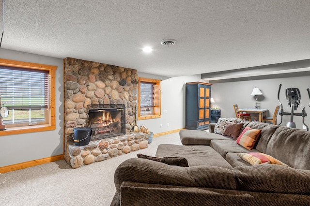 carpeted living room featuring a textured ceiling, baseboards, a wealth of natural light, and a fireplace