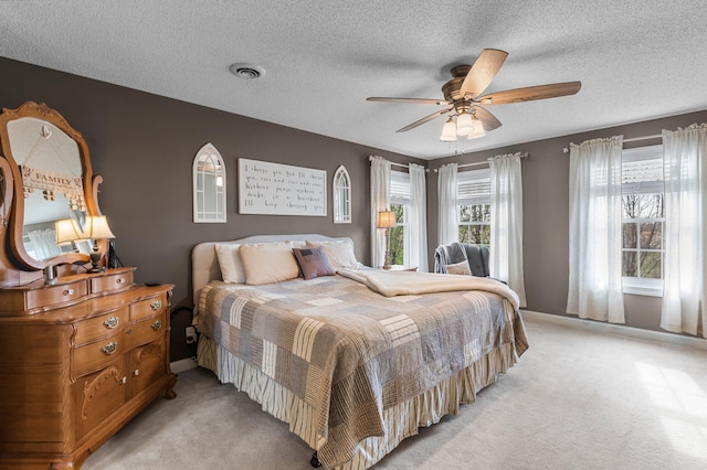 bedroom with a textured ceiling, light carpet, and baseboards