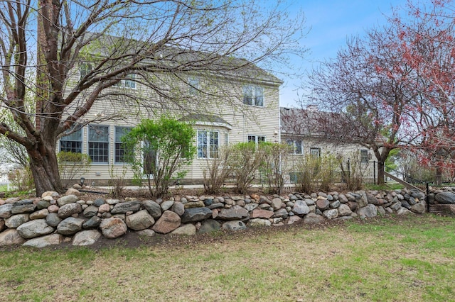 view of side of home with a lawn and fence