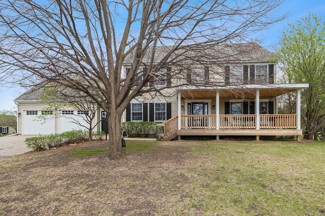 colonial inspired home featuring a garage, a front lawn, covered porch, and driveway