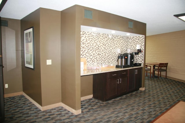 7200 York Ave S Unit 304, Edina, MN 55435 - kitchen featuring dark colored carpet, baseboards, dark brown cabinets, tasteful backsplash, and light stone counters