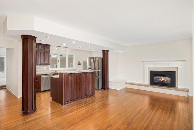 kitchen with open floor plan, light wood-type flooring, recessed lighting, a center island, and stainless steel appliances