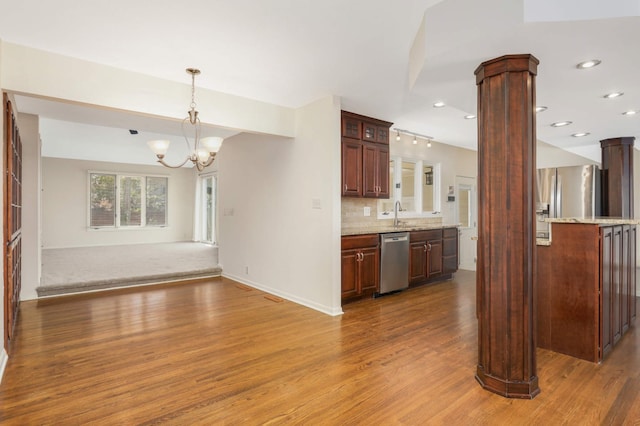 kitchen with wood finished floors, open floor plan, ornate columns, dishwasher, and a notable chandelier