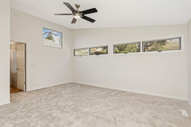 spare room with baseboards, a ceiling fan, carpet, and vaulted ceiling