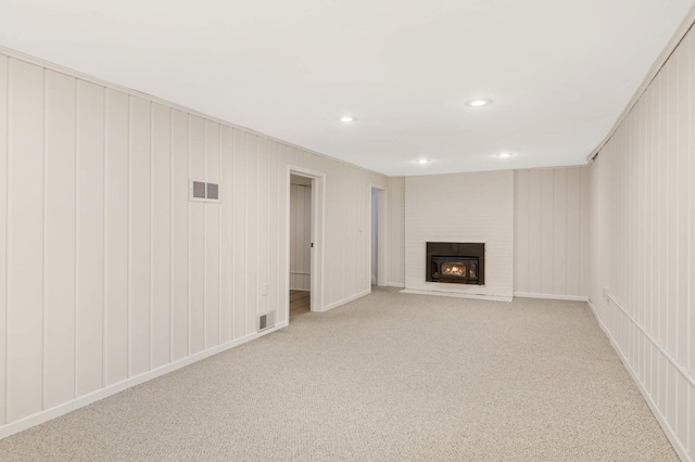 unfurnished living room with visible vents, recessed lighting, light carpet, and a fireplace
