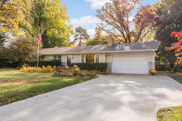 ranch-style home featuring an attached garage, driveway, a chimney, and a front yard