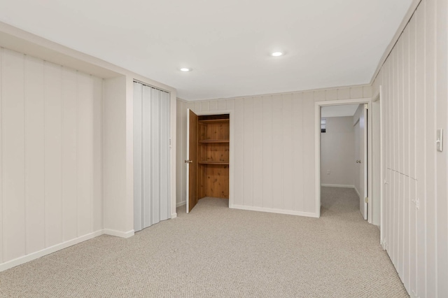 unfurnished bedroom with baseboards, light carpet, a closet, and recessed lighting