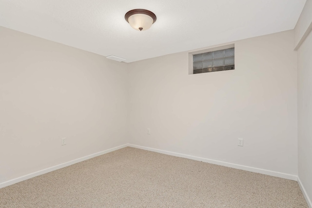 carpeted spare room featuring baseboards
