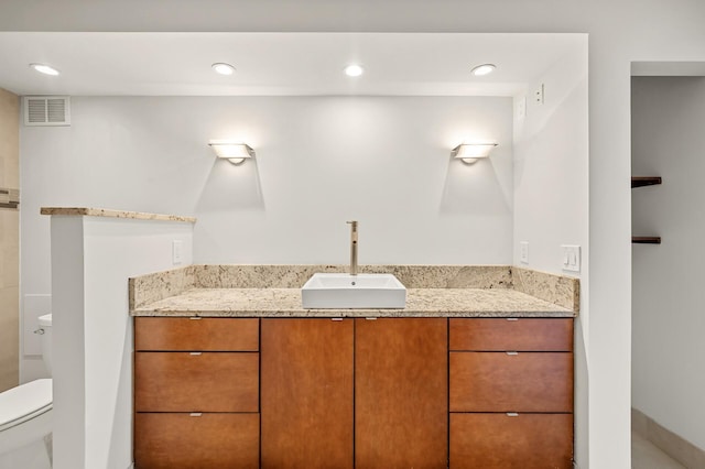 bathroom featuring visible vents, toilet, and vanity