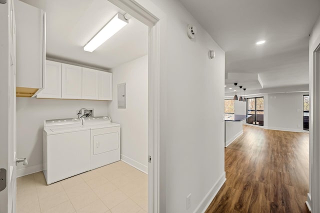 laundry area featuring baseboards, cabinet space, and washing machine and dryer