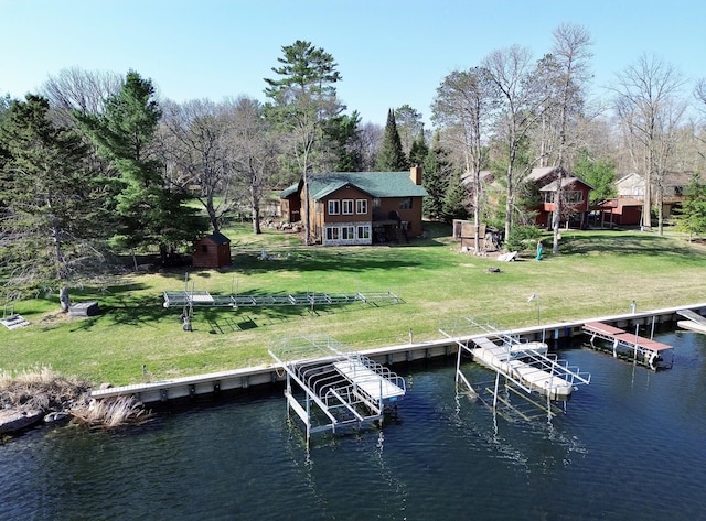 dock area with a water view and a yard