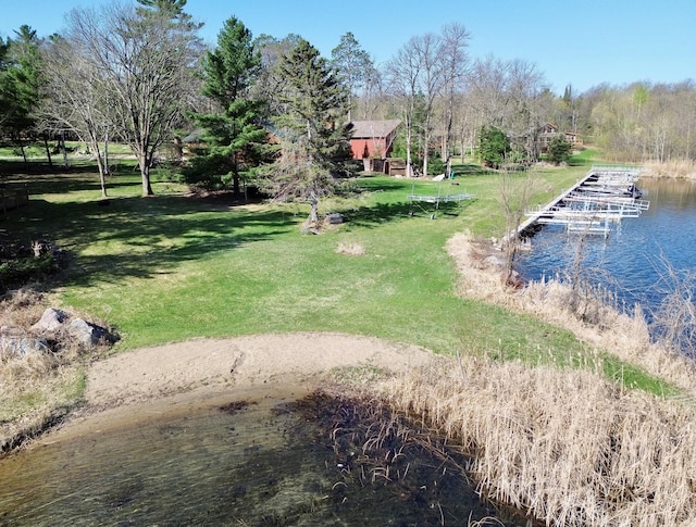 view of green lawn featuring a water view