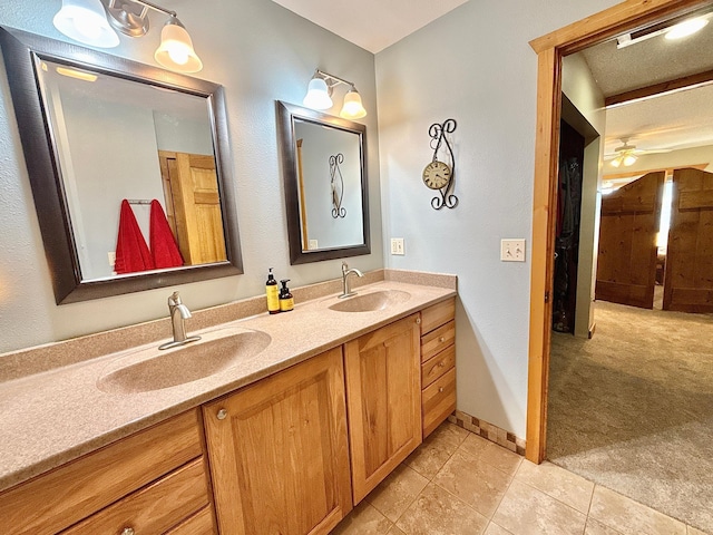 bathroom featuring double vanity, tile patterned floors, baseboards, and a ceiling fan