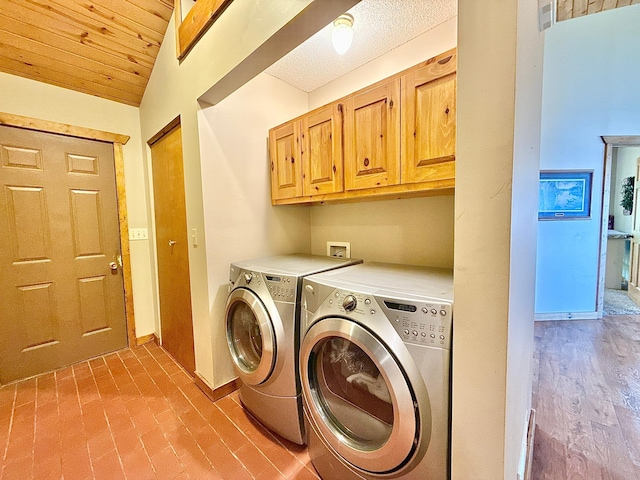 laundry area with washing machine and dryer, cabinet space, and baseboards