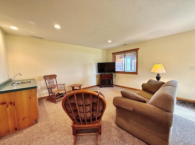 living room with carpet, recessed lighting, baseboards, and a textured ceiling