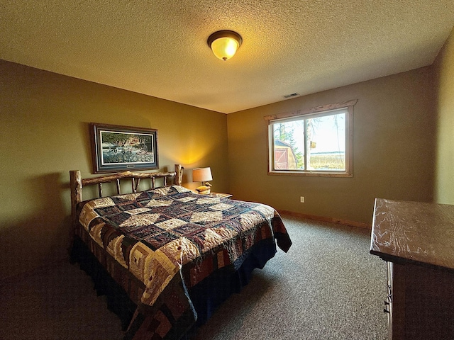 carpeted bedroom featuring a textured ceiling and baseboards