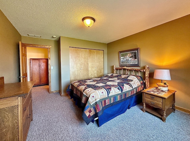 bedroom featuring carpet, a closet, a textured ceiling, and baseboards