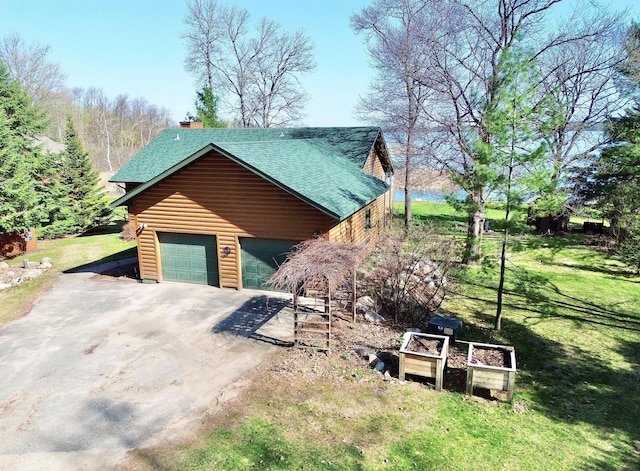 view of home's exterior with a yard, roof with shingles, a garage, and asphalt driveway