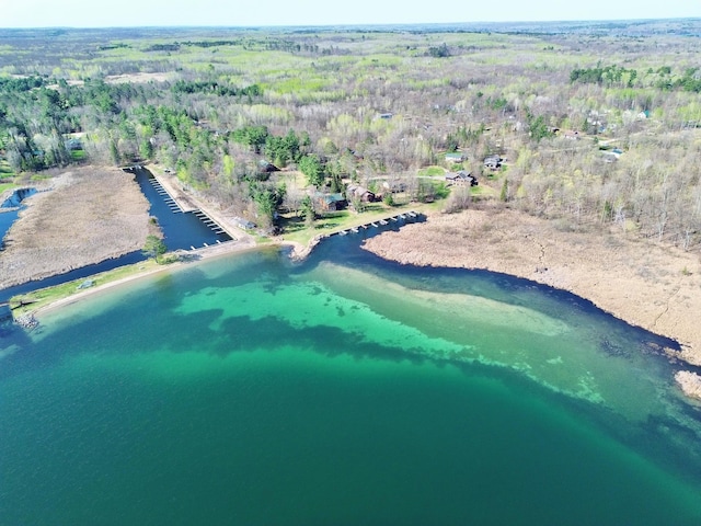aerial view of property's location with a heavily wooded area and a nearby body of water