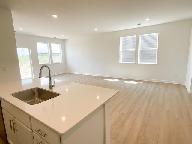 2458 Jandell Ave NE, Saint Michael, MN 55376 - kitchen with light wood-style floors, open floor plan, a kitchen island with sink, recessed lighting, and light stone counters