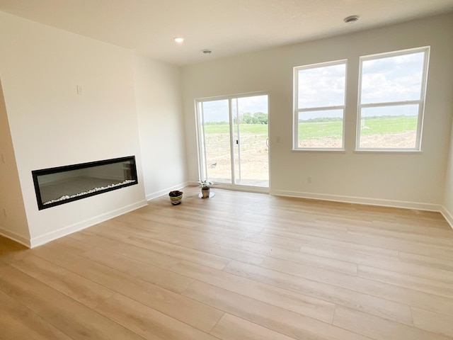 2458 Jandell Ave NE, Saint Michael, MN 55376 - unfurnished living room with a glass covered fireplace, light wood-type flooring, and recessed lighting